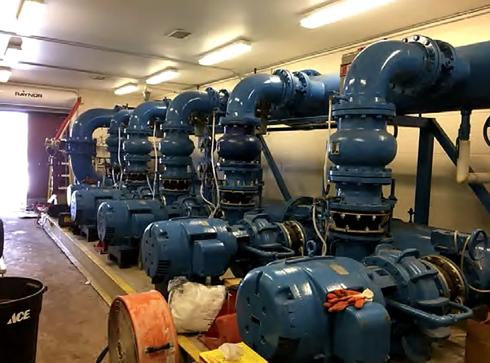 Row of large industrial pumps and motors in an upgraded pump room