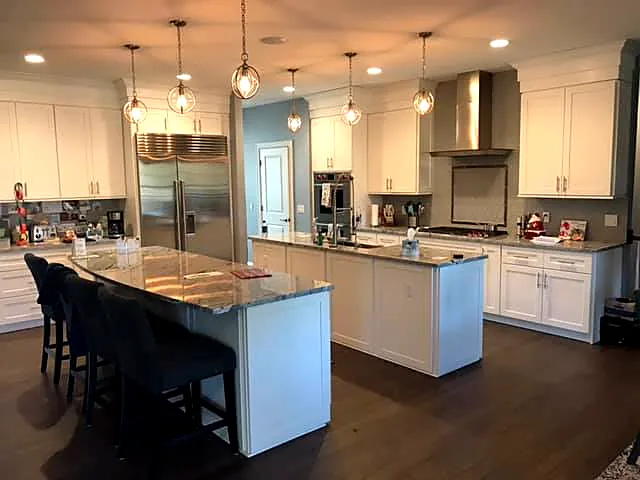 Kitchen with a large granite island, bar seating and pendant lights