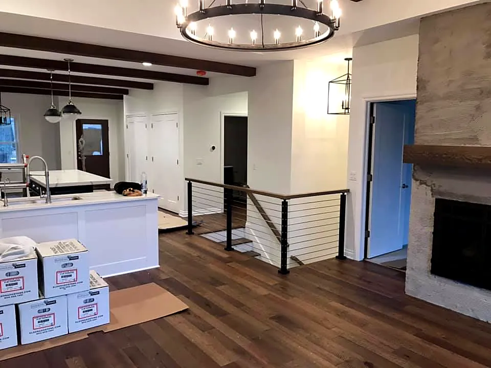 Open floor plan with kitchen island, fireplace and cable stair railing