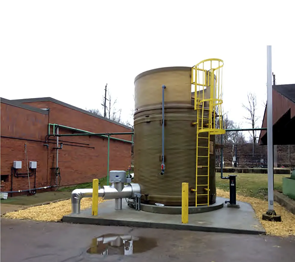 Above-ground tank with ladder, piping and bollards installed at a pump station